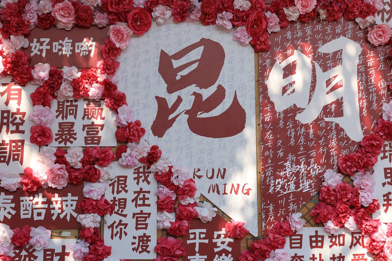 Vibrant floral display with Chinese calligraphy, featuring red and pink flowers accentuating traditional text.